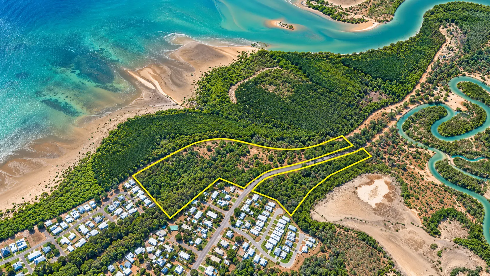 Aerial view of a coastal development parcel outlined in yellow beside turquoise water and mangroves